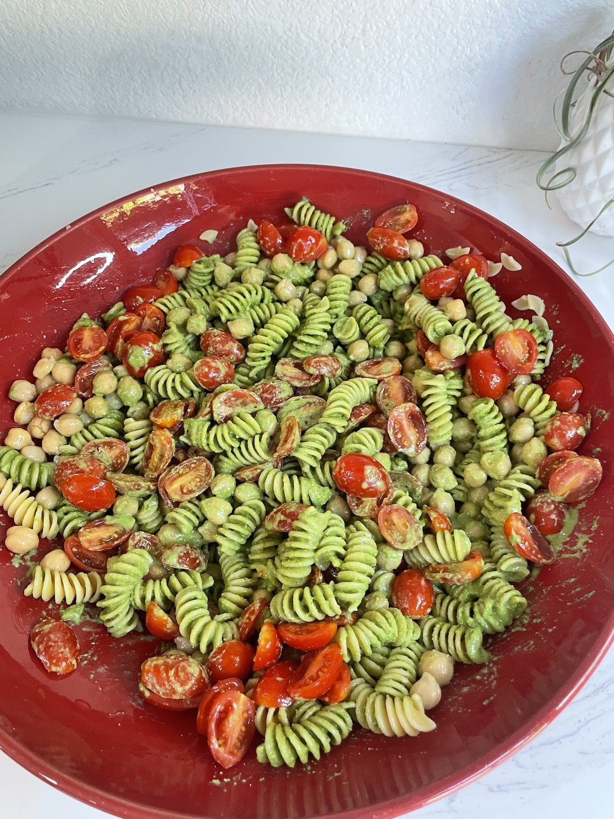 vegetarian pesto pasta dish in large red bowl